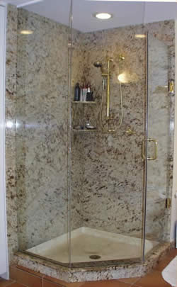 Private Residence, North Raleigh. This pre-existing shower was "dressed up" by the addition of slabs of granite on the shower walls. Use of the glass shower door trimmed in brass accents the stone nicely. The granite is Shiva Kashi. We discourage the use of marble and limestone in wet-to-