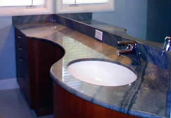Private Residence, North Raleigh. Asymmetric curves characterize this vanity of Imperial Blue Opal Serene quartzite. A tubular steel substrate, designed and fabricated by Prescott Stone Fabricators supports the vanity from underneath.