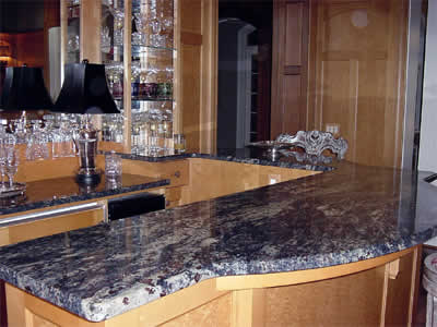 Private Residence, Chapel Hill. This cocktail bar, with a lower section and raised area for seating, was fabricated of Amadeus granite.  This granite is a jewel-tone navy blue with off-white veins and prominent garnets distributed throughout the stone.