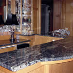Private Residence, Chapel Hill. This cocktail bar, with a lower section and raised area for seating, was fabricated of Amadeus granite.  This granite is a jewel-tone navy blue with off-white veins and prominent garnets distributed throughout the stone.